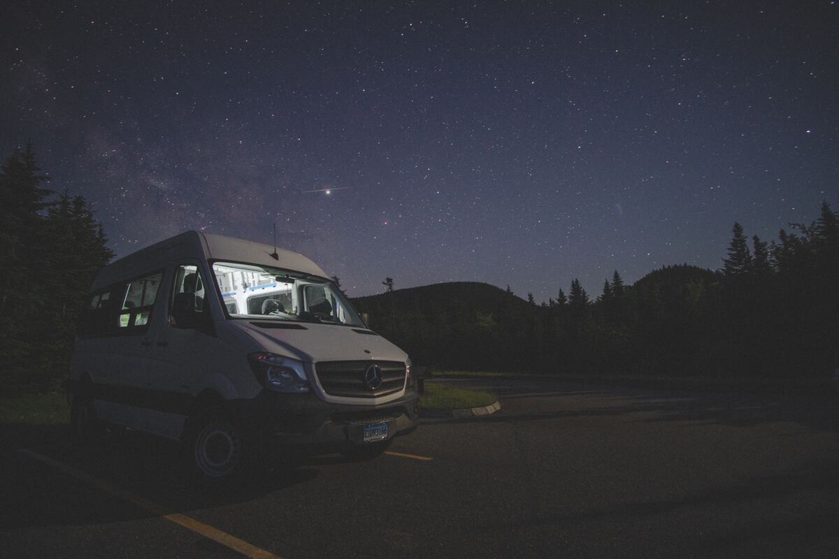 Un van garé la nuit sous un ciel étoilé